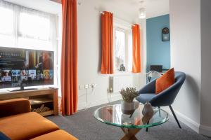 米尔顿凯恩斯Comfortable 4 Bedroom Home in Milton Keynes by HP Accommodation with Free Parking, WiFi & Sky TV的带沙发和玻璃桌的客厅