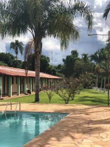索科罗Pousada Rancho Caipira的棕榈树和游泳池的房子
