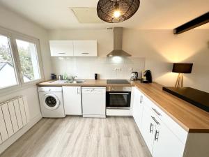 普洛埃默Appartement T3 cosy – Entre bourg et plages的厨房配有白色橱柜、洗衣机和烘干机