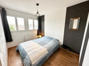 普洛埃默Appartement T3 cosy – Entre bourg et plages的一间卧室设有一张床和两个窗户。