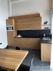 迪马罗Dolomia Apartments & Spa的厨房配有木制橱柜和木桌。
