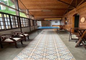彼得罗波利斯Casa acolhedora com lazer e espaço gourmet的大房间设有乒乓球桌和椅子