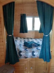BeslonRoulot'So Zen的一间卧室配有一张带蓝色窗帘的床和一扇窗户