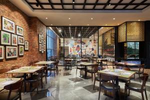 吉隆坡Four Points by Sheraton Kuala Lumpur, Chinatown的一间带桌椅的餐厅以及砖墙