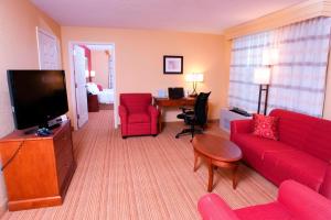 米德尔堡米德尔伯里万怡酒店的客厅配有红色沙发和电视