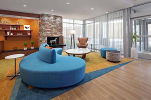 波普勒布拉夫Fairfield Inn & Suites by Marriott Poplar Bluff的一个带蓝色搁脚凳和椅子的大客厅