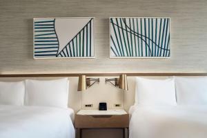 墨西哥城JW Marriott Hotel Mexico City Polanco的两张位于酒店客房的床,墙上有两张照片