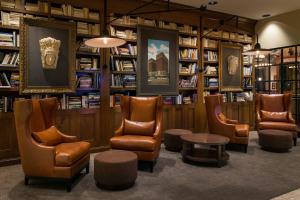 林垦林肯万豪酒店&度假村的图书馆配有椅子、桌子和书架