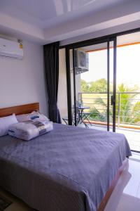 迈考海滩777 Beach Condo Phuket的一间卧室设有一张床和一个大窗户