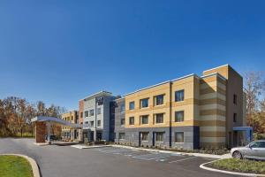 奥尔巴尼Fairfield Inn & Suites by Marriott Albany Airport的停车场内有停车位的公寓大楼