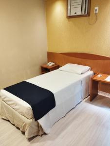 圣保罗巴西利亚桑塔纳黄金公寓酒店的酒店客房,设有一张床和两张桌子
