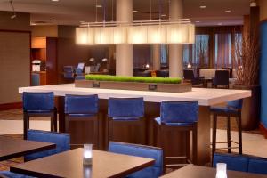 肖尼堪萨斯城肖尼万怡酒店的餐厅设有酒吧,配有蓝色的桌椅