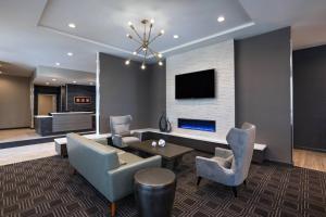 欧文TownePlace Suites by Marriott Dallas DFW Airport North/Irving的客厅配有桌椅和电视。