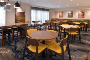 阿林顿阿林顿六旗乐园附近费尔菲尔德客栈的用餐室配有桌子和黄色椅子