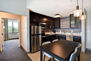 梅森Residence Inn by Marriott Cincinnati Northeast/Mason的厨房配有木桌和冰箱。
