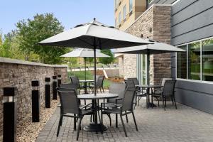 博伊西Fairfield Inn & Suites by Marriott Boise West的一个带桌椅和遮阳伞的庭院