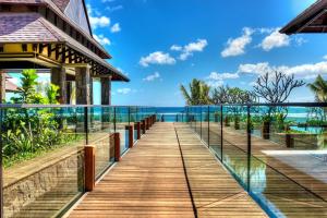 巴拉克拉瓦The Westin Turtle Bay Resort & Spa, Mauritius的一条木制走道,通往一座背靠大海的房子