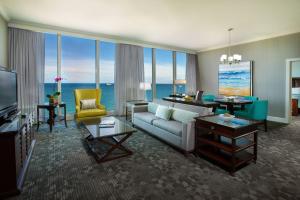 劳德代尔堡Courtyard by Marriott Fort Lauderdale Beach的带沙发和电视的客厅以及部分窗户。