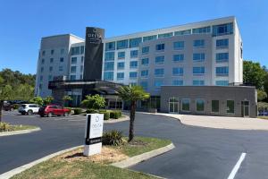 达拉姆Delta Hotels by Marriott Raleigh-Durham at Research Triangle Park的大型建筑前的停车场