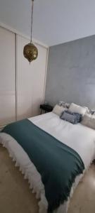 塞维利亚LA CASITA DE LA PUERTA DE CARMONA的一间卧室配有一张大床,提供蓝白色的毯子