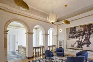 华沙Hotel Verte, Warsaw, Autograph Collection的大堂设有蓝色椅子和墙上的绘画作品