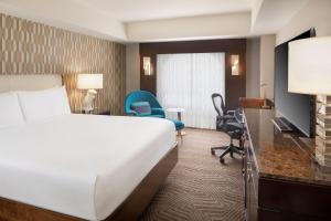 凤凰城凤凰城市中心万丽酒店的酒店客房,配有一张床、一张桌子和椅子