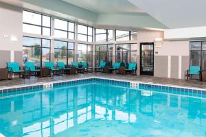 亚克朗阿克伦南/格林住宿酒店的一座带蓝色椅子和窗户的游泳池