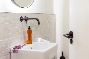 马略卡岛帕尔马Samaritana Suites的浴室配有水槽、水龙头和镜子