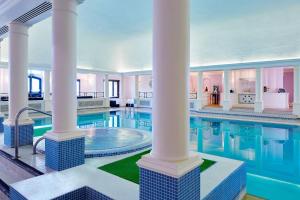 韦尔汉伯瑞曼诺万豪酒店及乡村俱乐部 的一个带柱子的大型游泳池和一个大型游泳池