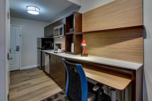 萨拉兰TownePlace Suites by Marriott Mobile Saraland的厨房配有柜台和带蓝椅的书桌