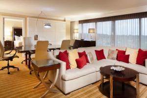孟菲斯孟菲斯东部万豪酒店的客厅配有白色沙发和红色枕头。