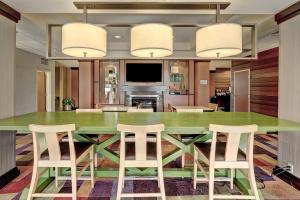 爱迪生南普兰菲尔德豪费尔菲尔德埃蒂森套房酒店的一间设有一张绿色大桌子和椅子的用餐室
