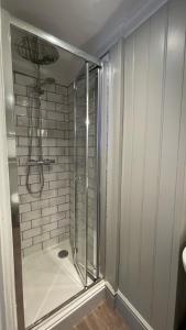 梅奈布里奇安格尔西纹章酒店的浴室里设有玻璃门淋浴