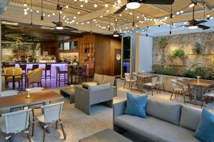 萨拉索塔The Sarasota Modern, a Tribute Portfolio Hotel的一间带桌椅的餐厅和一间酒吧