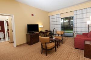 佛罗伦萨南卡罗来纳州佛罗伦斯万怡酒店的带沙发、桌子和电视的客厅