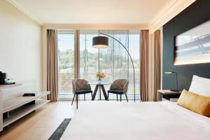 里昂里昂塞特万豪国际酒店的一间卧室配有一张床和一张桌子及椅子