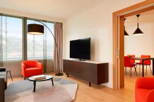 里昂里昂塞特万豪国际酒店的一间带电视和红色椅子的客厅