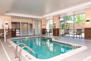 卡梅尔Fairfield Inn & Suites by Marriott Indianapolis Carmel的一个带椅子和桌子的大型游泳池