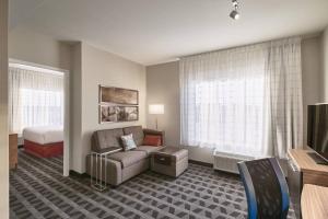梅迪辛哈特TownePlace Suites by Marriott Medicine Hat的酒店客房设有一张沙发和一张床