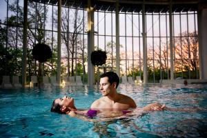 斯帕Luxury Spa Hotel - Francofolies的游泳池里的男人和女人