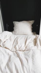 哥本哈根哥本哈根308公寓的一张带白色床单和枕头的未铺好的床