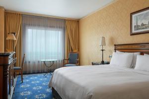 罗马罗马万豪公园酒店的酒店客房设有床、桌子和窗户。
