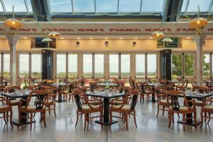 罗马罗马万豪公园酒店的用餐室设有桌椅和窗户。