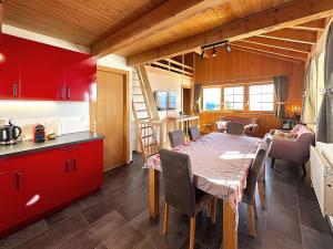 安塞热Zigzag on the slopes的厨房以及带桌子和红色橱柜的用餐室。