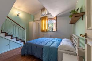 蒙德罗Bouganville Home Mondello的一间卧室配有一张带蓝色毯子的床