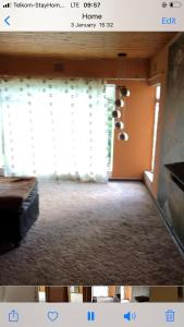 范德拜尔帕克Ulwazi lodge的带沙发的客厅和部分窗户。