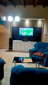 贝伦Casa de campo的客厅配有2把蓝色椅子和电视