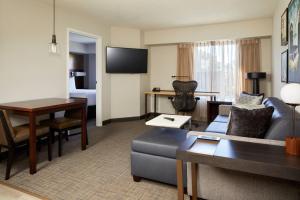 卡尔斯巴德圣地亚哥卡尔斯巴德公寓式酒店的客厅配有沙发和桌子