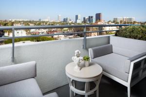 洛杉矶SLS贝弗利山豪华精选酒店的阳台设有沙发和桌子,享有美景。