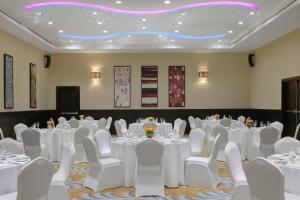 吉赞吉赞万怡酒店的一间会议室,配有白色的桌子和白色的椅子